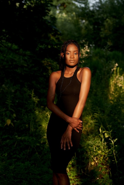 Portrait of beautiful african american woman standing in forest near trees