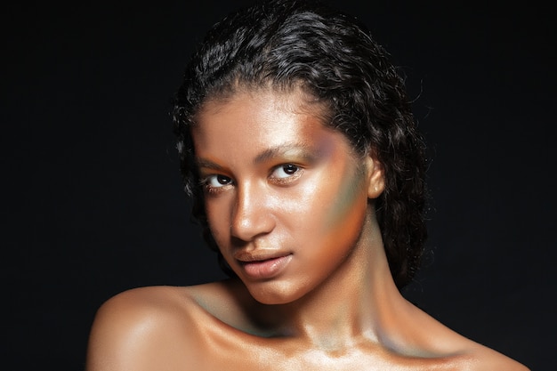 Portrait of beautiful american young woman with shining makeup over black