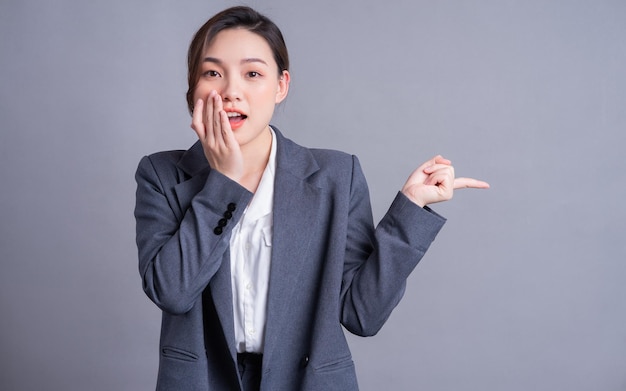 Portrait of a beautiful Asian businesswoman on a gray background