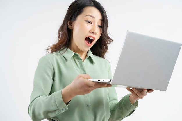 Portrait of the beautiful Asian businesswoman looking at the laptop screen with a surprised look