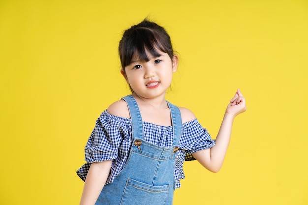 Portrait of a beautiful asian girl isolated on yellow background