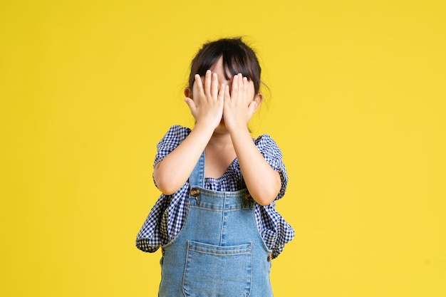 Portrait of a beautiful asian girl isolated on yellow background