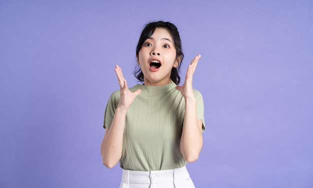 Portrait of beautiful Asian girl posing on purple background