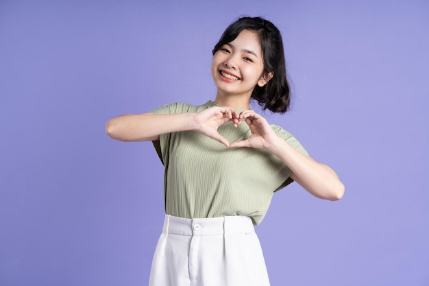 Portrait of beautiful Asian girl posing on purple background