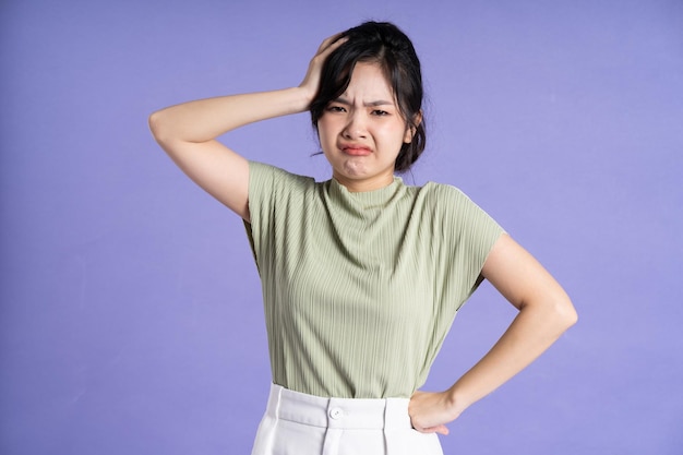 Portrait of beautiful Asian girl posing on purple background