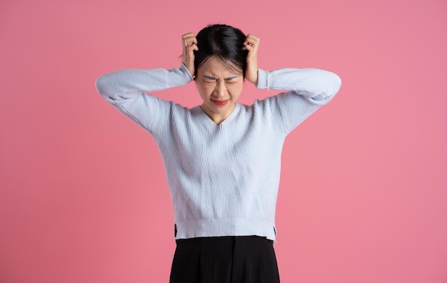 Portrait of beautiful asian woman posing on pink background