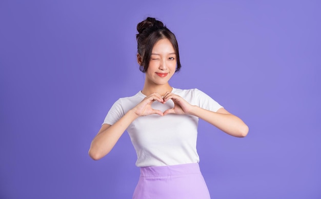 Portrait of a beautiful Asian woman posing on a purple background