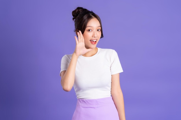 Portrait of a beautiful Asian woman posing on a purple background