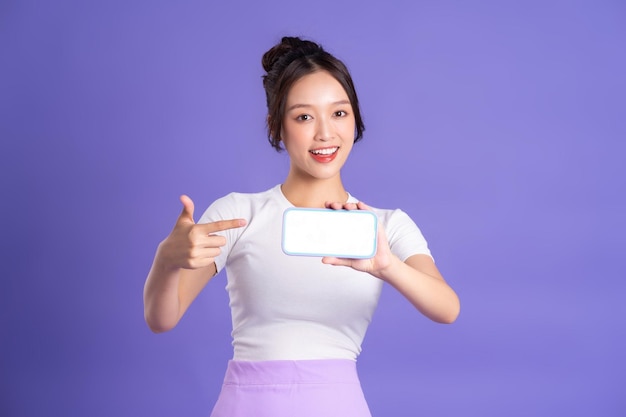 Portrait of a beautiful Asian woman posing on a purple background