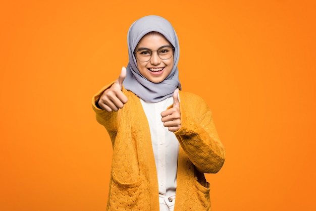 Portrait of beautiful Asian woman smiling showing thumbs up, approved and like something