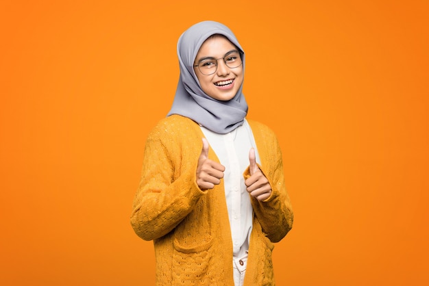 Portrait of beautiful Asian woman smiling showing thumbs up, approved and like something