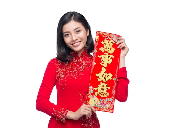 Portrait of a beautiful Asian woman on traditional festival costume Ao Dai showing  New Year scrolls Tet holiday. Lunar New Year. Text mean Always Lucky.