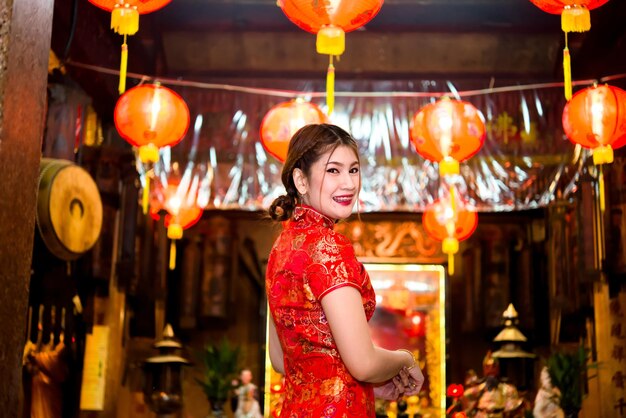 Portrait of beautiful asian woman wear cheongsam on light of lantern backgroundHappy chinese new yearThailand people