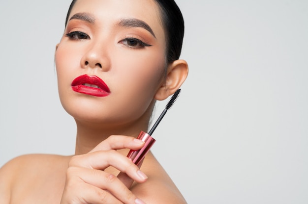 Portrait of Beautiful Asian woman with mascara in hand