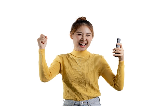 Portrait of a beautiful Asian woman in a yellow shirt playing on a smartphone portrait concept used for advertisement and signage isolated over the blank background copy space