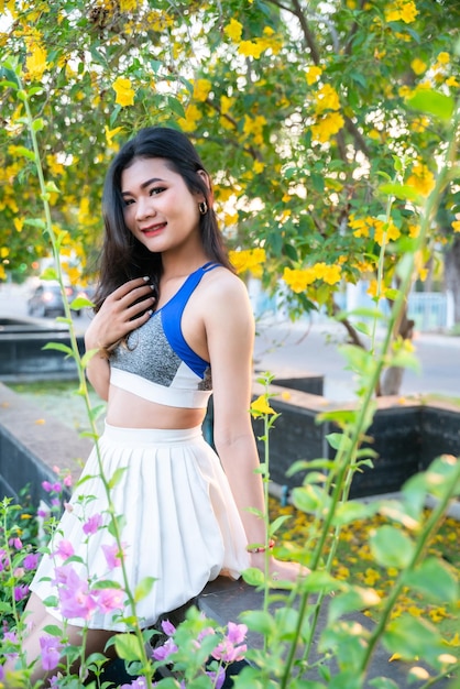 Portrait of beautiful athletic young asian woman in fashionable sportswear standing and having rest after strong exercise training in garden the parkOutdoor Sporty concept