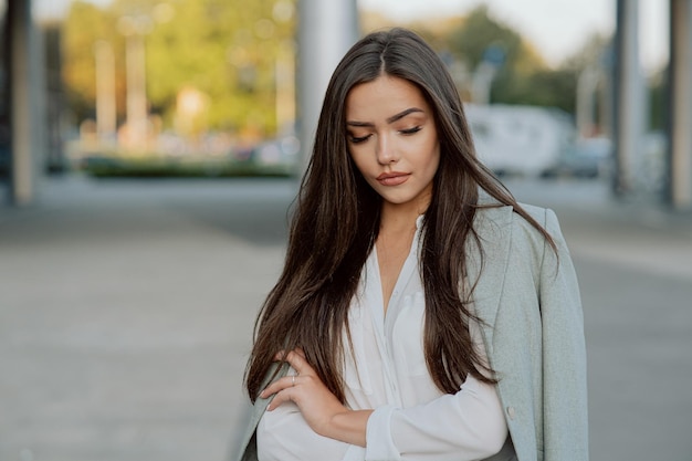 Portrait of a beautiful attractive sexy woman brunette with long hair and dark eyes looks down