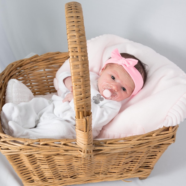 Portrait of a beautiful baby girl  lying in a basket.