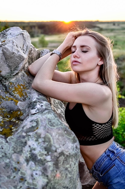 Portrait of a beautiful blonde girl with her eyes closed in summer in nature