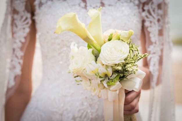 Portrait of the beautiful bride holding the bouquet 