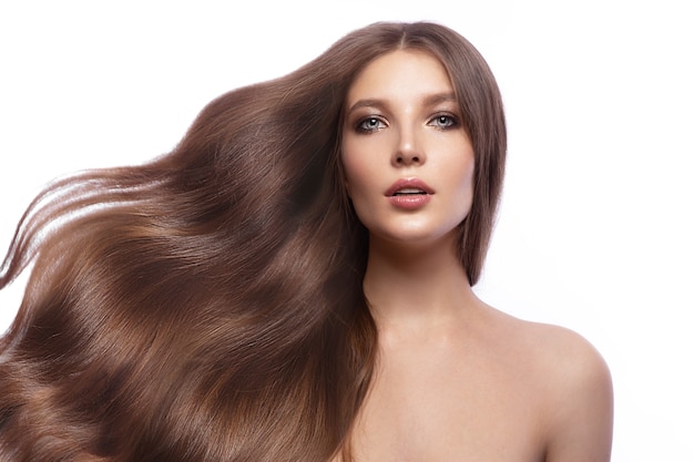 Portrait of beautiful brown-haired woman with a perfectly curls hair, and classic make-up. Beauty face and hair. Picture taken in the studio on a white background.