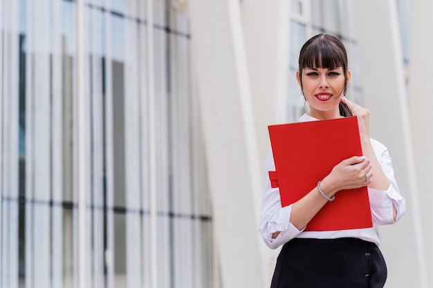 Portrait of beautiful business woman holding notebook on her way to work