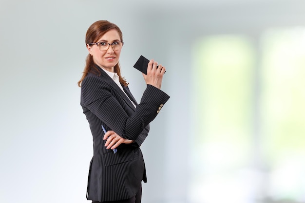 Portrait of a beautiful businesswoman 50 ears old with mobile phone in the office