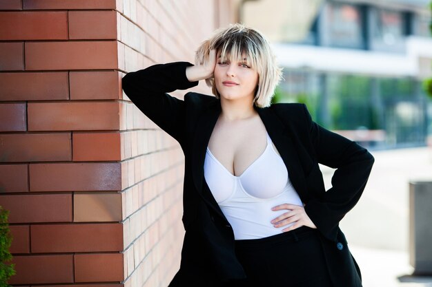 Portrait of a beautiful businesswoman in a black suit on the street