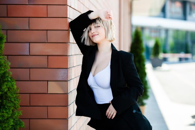 Portrait of a beautiful businesswoman in a black suit on the street