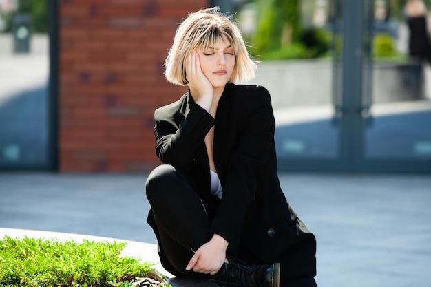 Portrait of a beautiful businesswoman in a black suit on the street