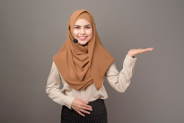 Portrait of beautiful call center woman with hijab on gray