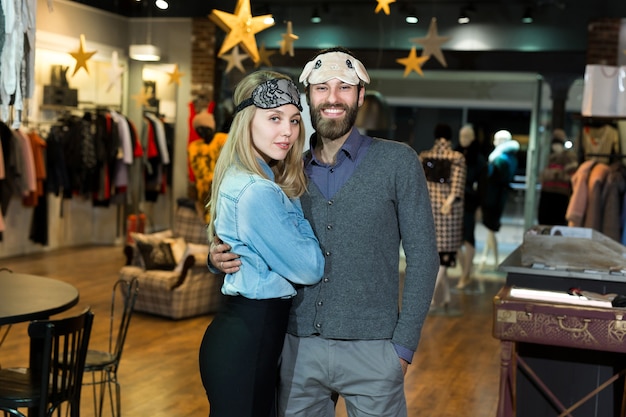 Portrait of a beautiful couple in a sleep mask in a clothing store