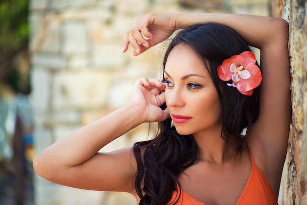 Portrait of beautiful dark-haired smiling girl against the backdrop of medieval stone buildings in the town of Altos de Chavon, Dominican Republic