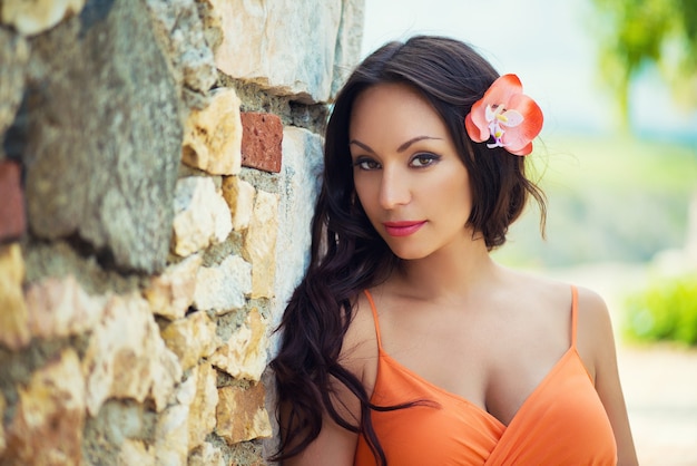 Portrait of beautiful dark-haired smiling girl against the backdrop of medieval stone buildings in the town of Altos de Chavon, Dominican Republic