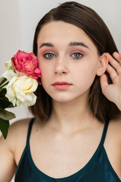 Portrait of beautiful dark-haired woman with flowers. Fashion photo, Pretty little girl with pink rose