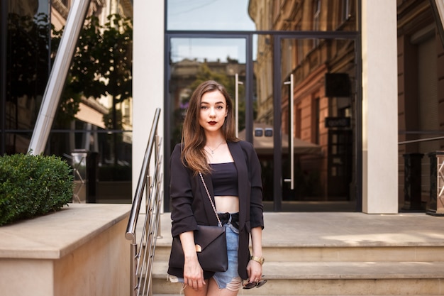 portrait of a beautiful girl on the background of a glass building