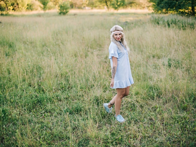 Portrait of a beautiful girl in a blue dress in a field