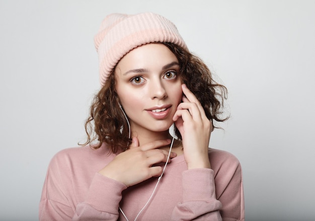 Portrait of a beautiful girl in headphones listens to music and smiles