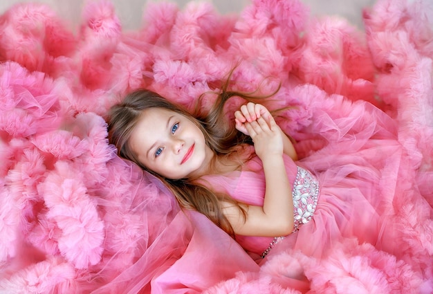 portrait of a beautiful girl in a lush pink dress