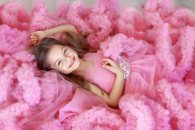 portrait of a beautiful girl in a lush pink dress