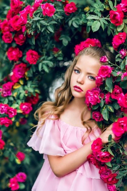 Portrait of a beautiful girl in rose flowers