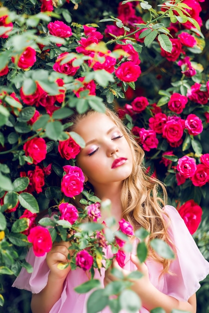 Portrait of a beautiful girl in rose flowers