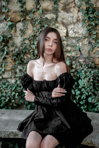 Portrait of a beautiful girl sitting on a stone