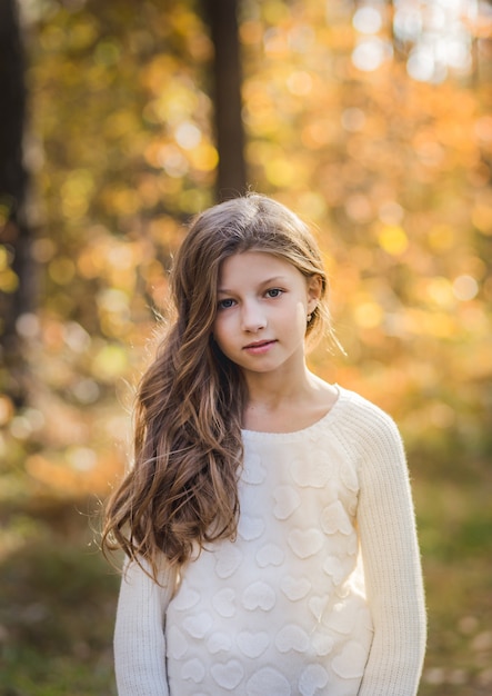 portrait of a beautiful girl with long hair on nature in summer