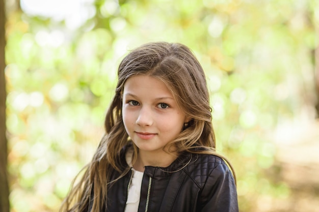 portrait of a beautiful girl with long hair on nature in summer