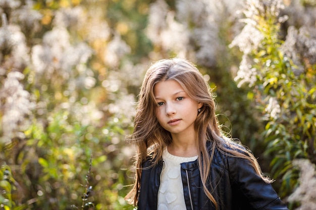 portrait of a beautiful girl with long hair on nature in summer