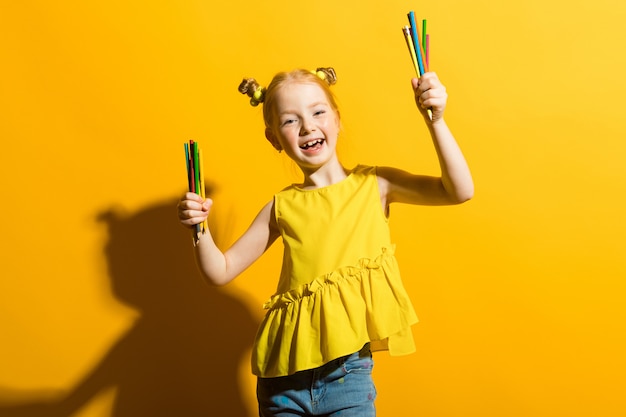 Portrait of a beautiful girl in a yellow blouse and blue jeans.