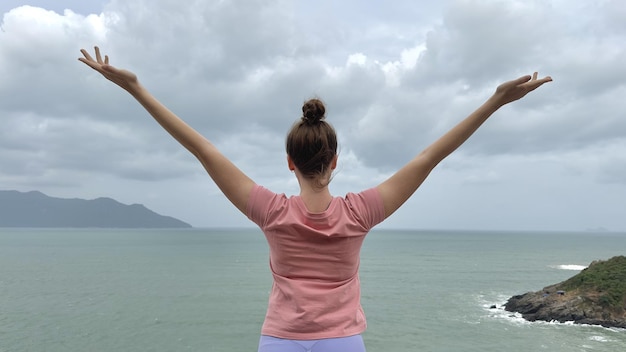 Portrait of beautiful girl young happy carefree relaxed woman at sea ocean background enjoying summer sunny day vacation on mountain smiling in tropical country practice yoga meditating