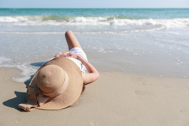 Portrait of beautiful and happiness woman enjoy holiday vacation and lying down on the beach