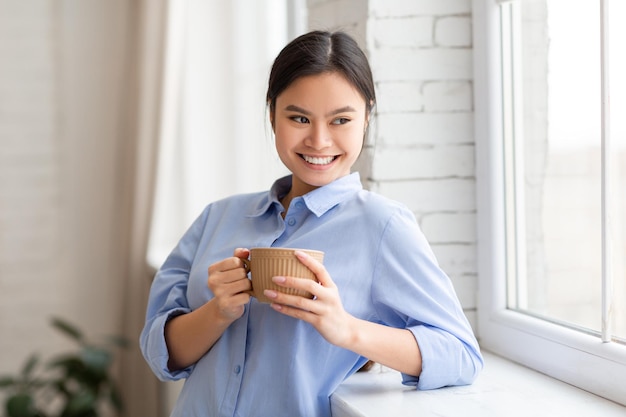 Portrait of beautiful happy asian woman drinking coffee